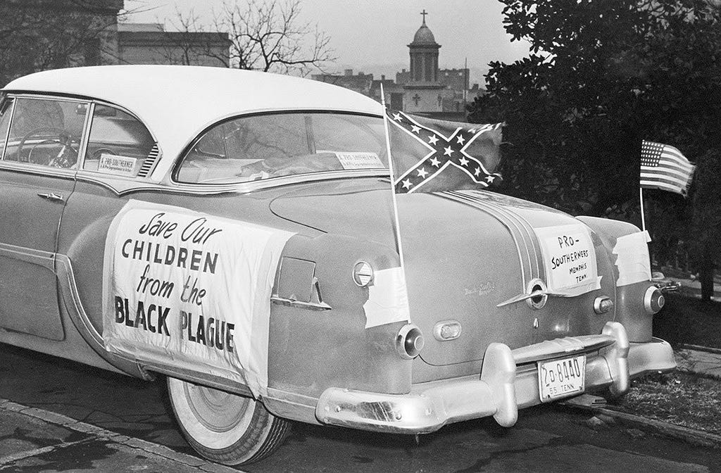 “Salve nossas crianças da praga negra”
 
Bandeira dos Estados Confederados e dos EUA tremulam em carro estacionado no Capitol Hill, em Nashville, onde o então governador Frank Clemente se encontrava com uma delegação de partidários do segregacionismo em 24 de janeiro de 1956.