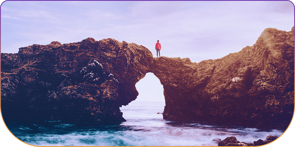 Man standing on top of 2 joined rocks