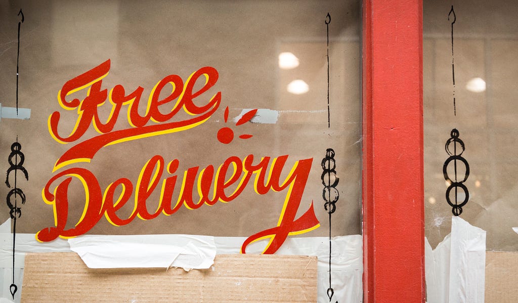 A storefront with a “Free Delivery” sign