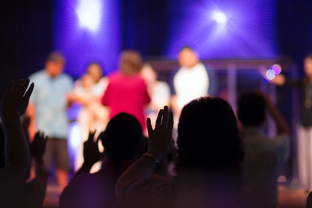 A group of people raises their hands for an opportinutity to speek