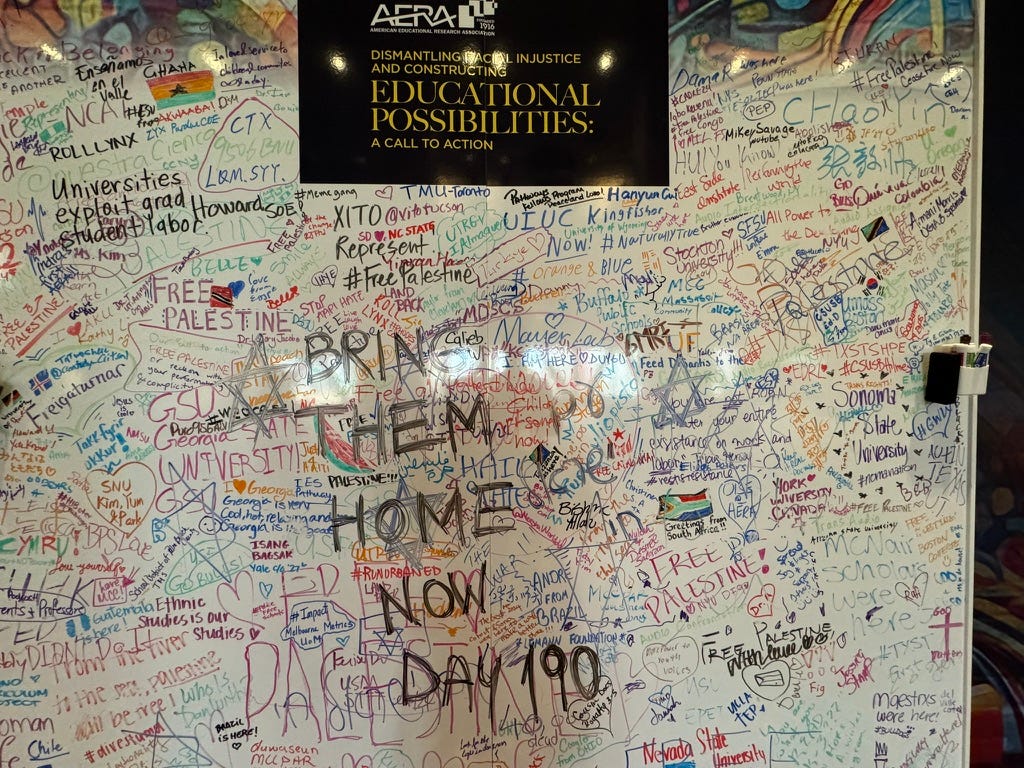 A white board full of hundreds of statements, including “Bring them home now day 190” in black ink.