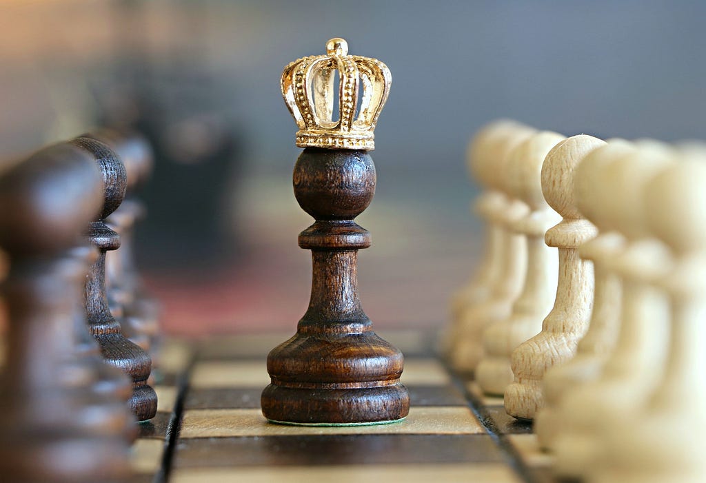 A chess piece with a golden crown on its top