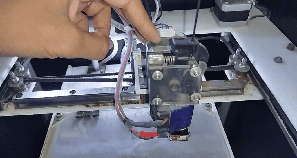 Calibrating the heart of innovation: A hands-on adjustment of the 3D printer’s extruder motor.