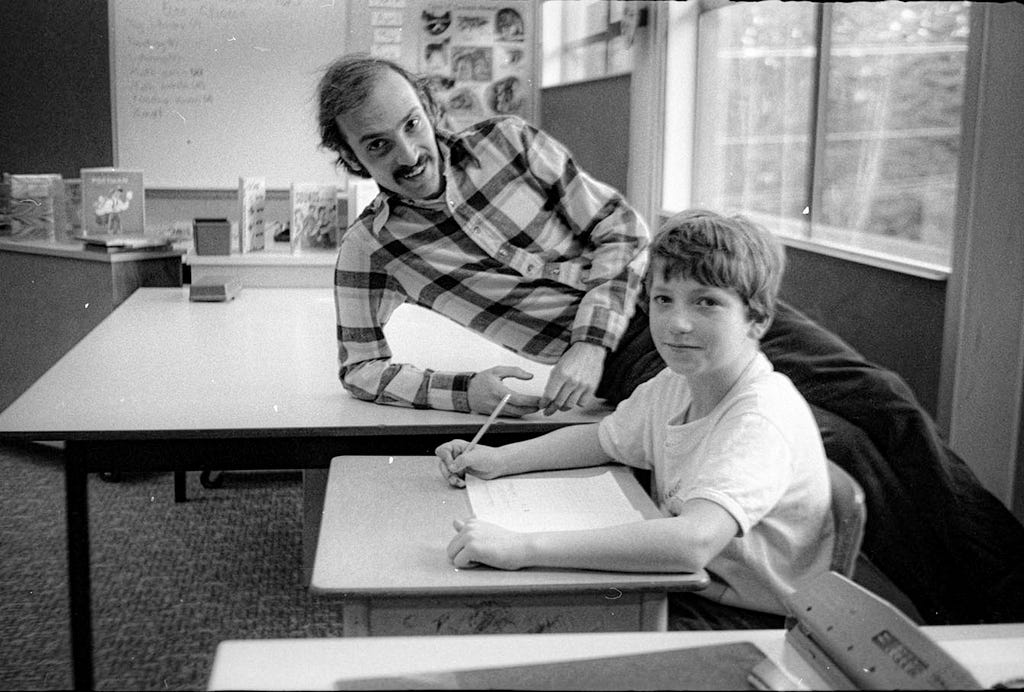 man on a desk teaching a student