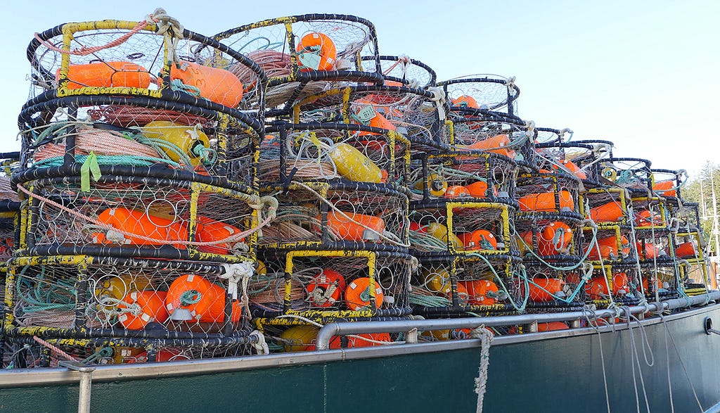 Stacks of crab pots fill the deck of a fishing boat.