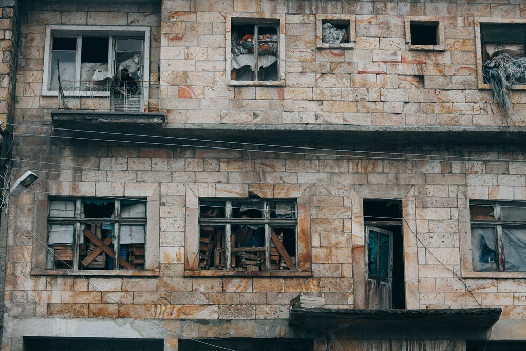 An old building that looks abandoned with many windows broken