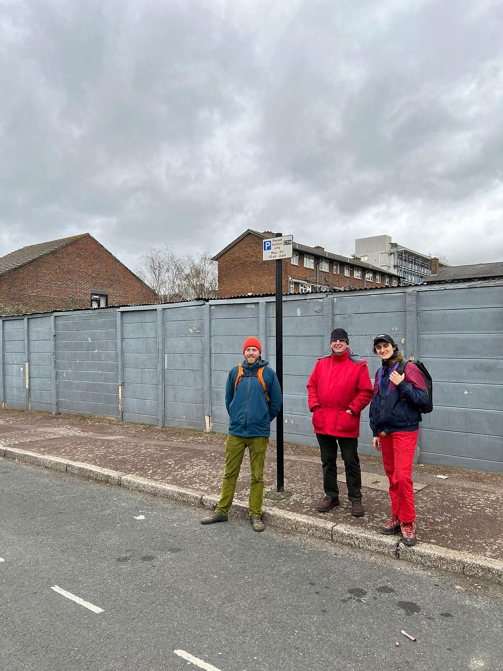 Three individuals standing near a fence by the road. This is a picture from our site visit of E16 CLT