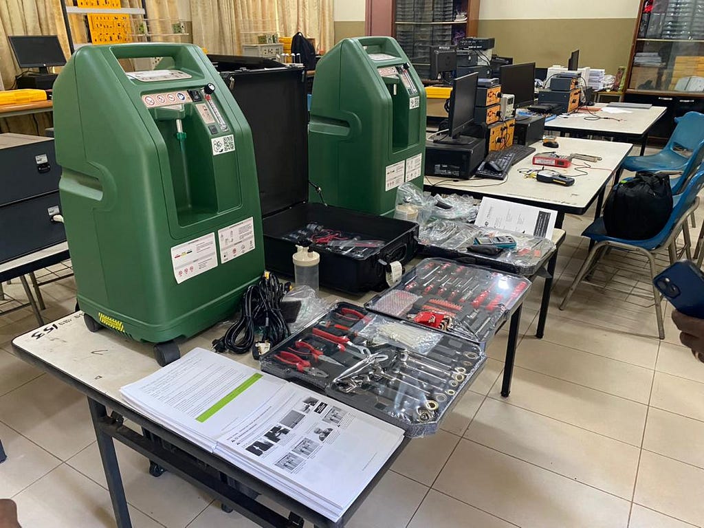 An image of two PulmO2 oxygen concentrators on a workshop table surrounded by tools.