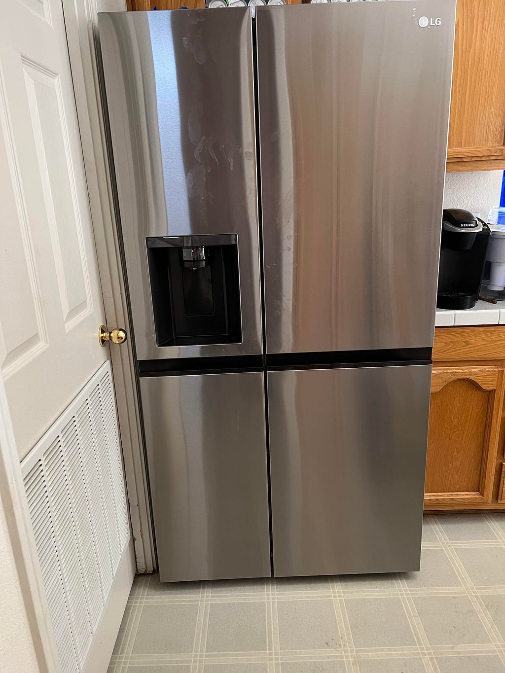 picture of a stainless steel refrigerator, with side-by-side doors, and a water and ice dispenser on the front of the left-hand door