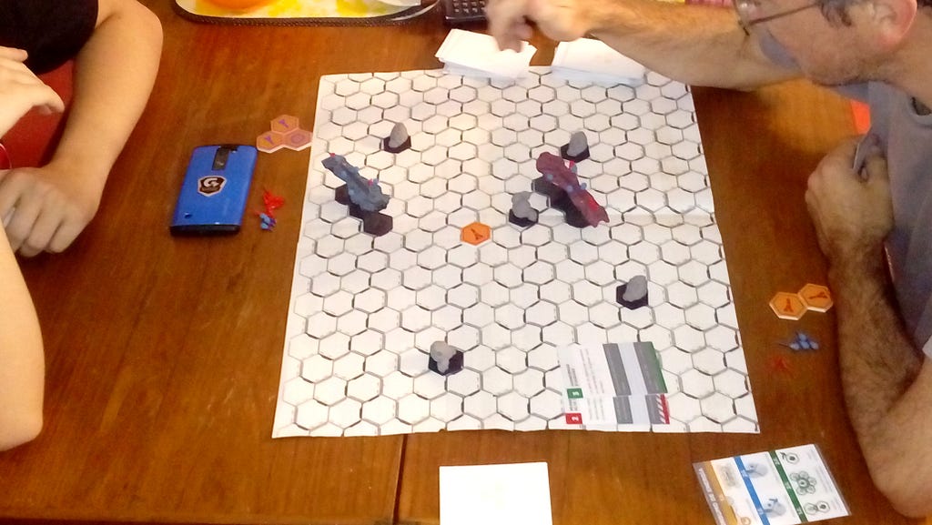Two people playing the game and evaluating how to move their pieces on the board.
