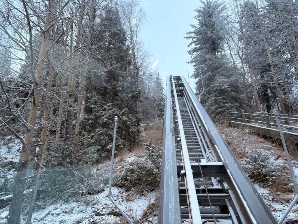 A snowy funicular, from the bottom, staring up at the sky.