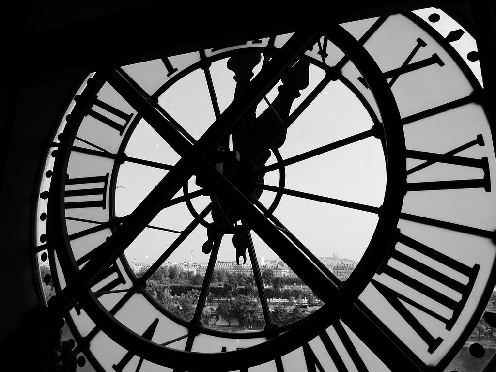 a massive clock architecture in plain steel covering the city view in the background black and white picture