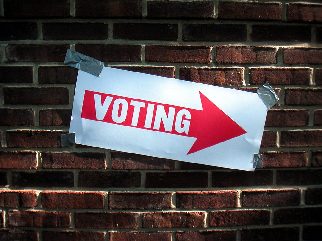 Voting sign taped to a wall. Courtesy Keith Ivey via flickr.