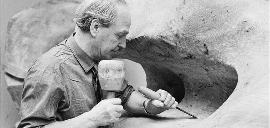 Black and white picture of a sculpturer Henry Moore at work.