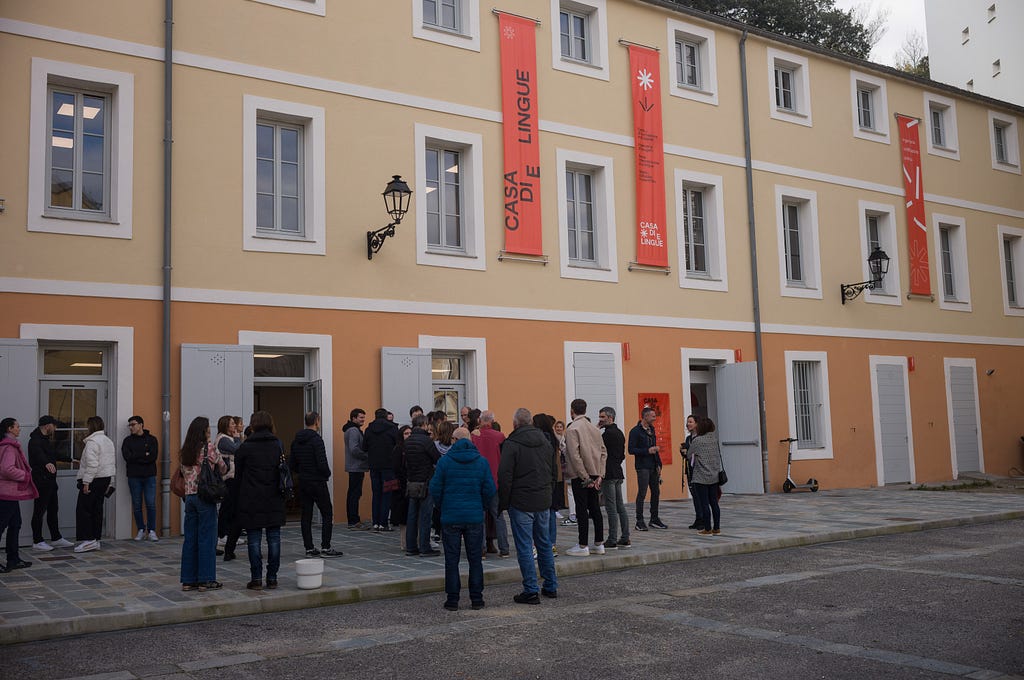 A crowd gathers outside Casa di e lingue, a mother-tongue institute in Bastia, Corsica