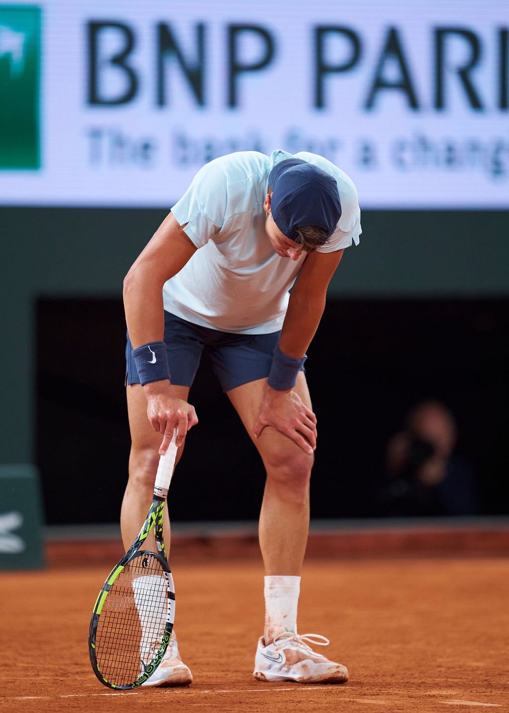 A crestfallen Holger Rune drops to his haunches at Roland Garros. | Image Credit: AllAboutHQ/X via Getty Images