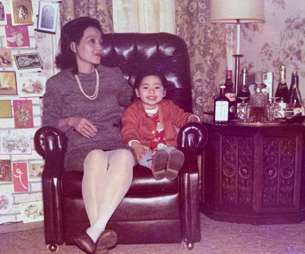 A woman and her young daughter sharing an armchair.
