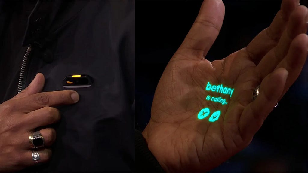 A person wearing a small brooch-like device on their jacket; A light projection of an interface on a person’s hand