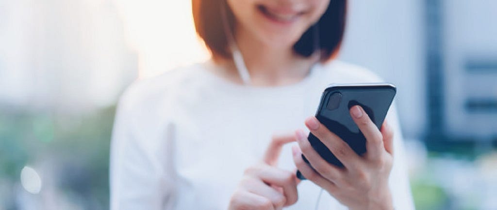 Young woman observing screen of mobile phone