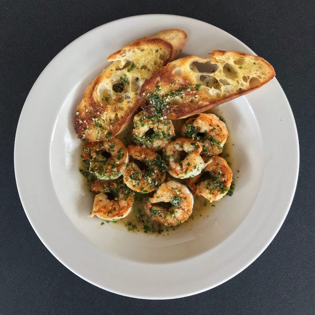 Shrimp Scampi plated with a side of toasted bread