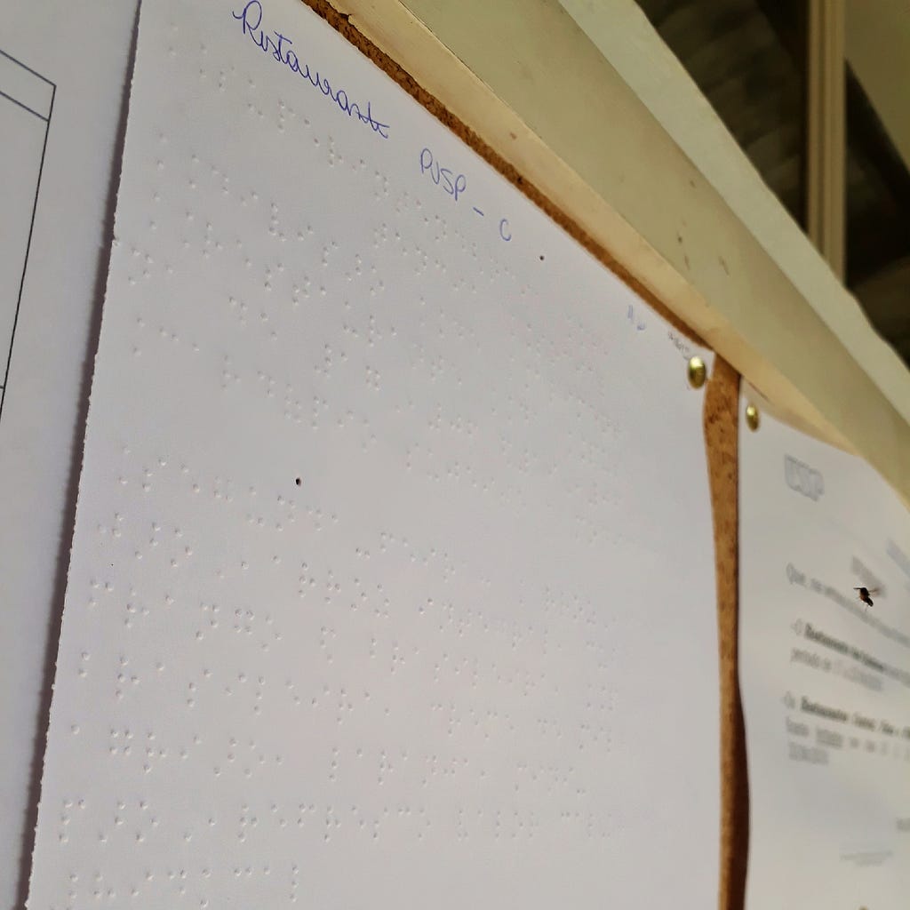 Cardápio em Braille exposto no mural do restaurante PUSP-C na Universidade de São Paulo.