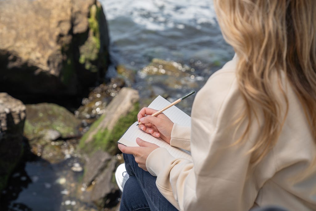 Girl is writing in her journal in the nature.