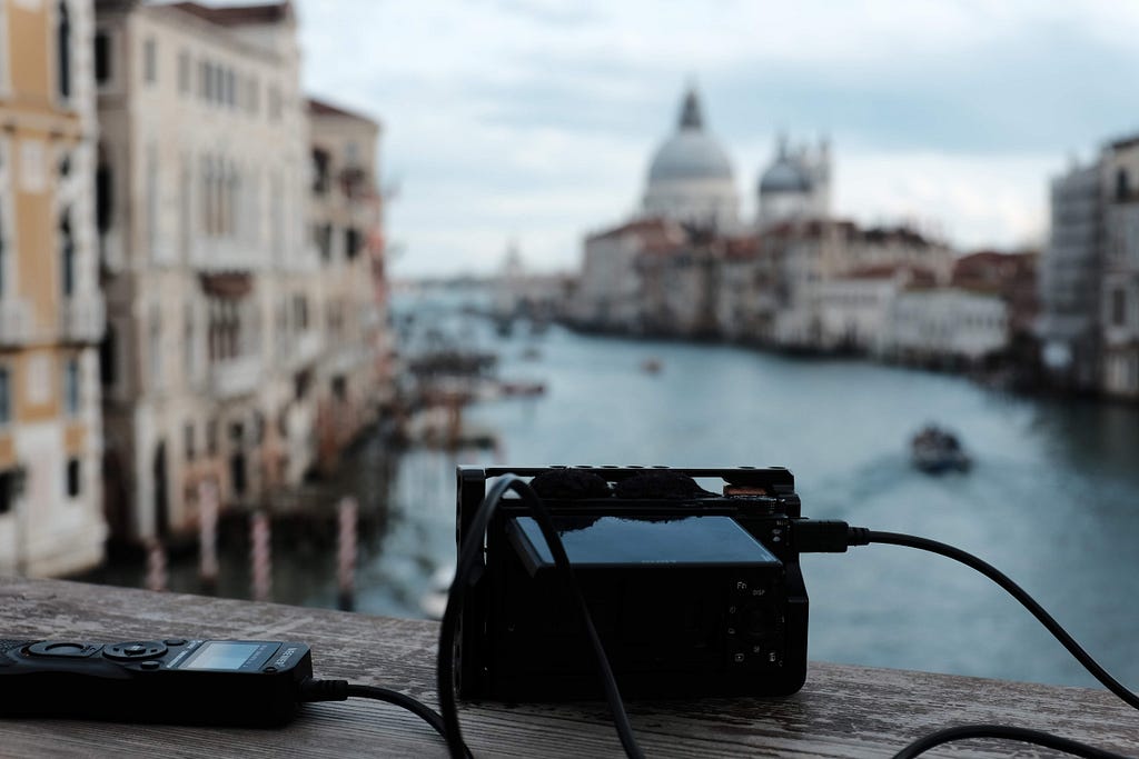 small digital camera with cable release in foreground, blurry Venice canal in background
