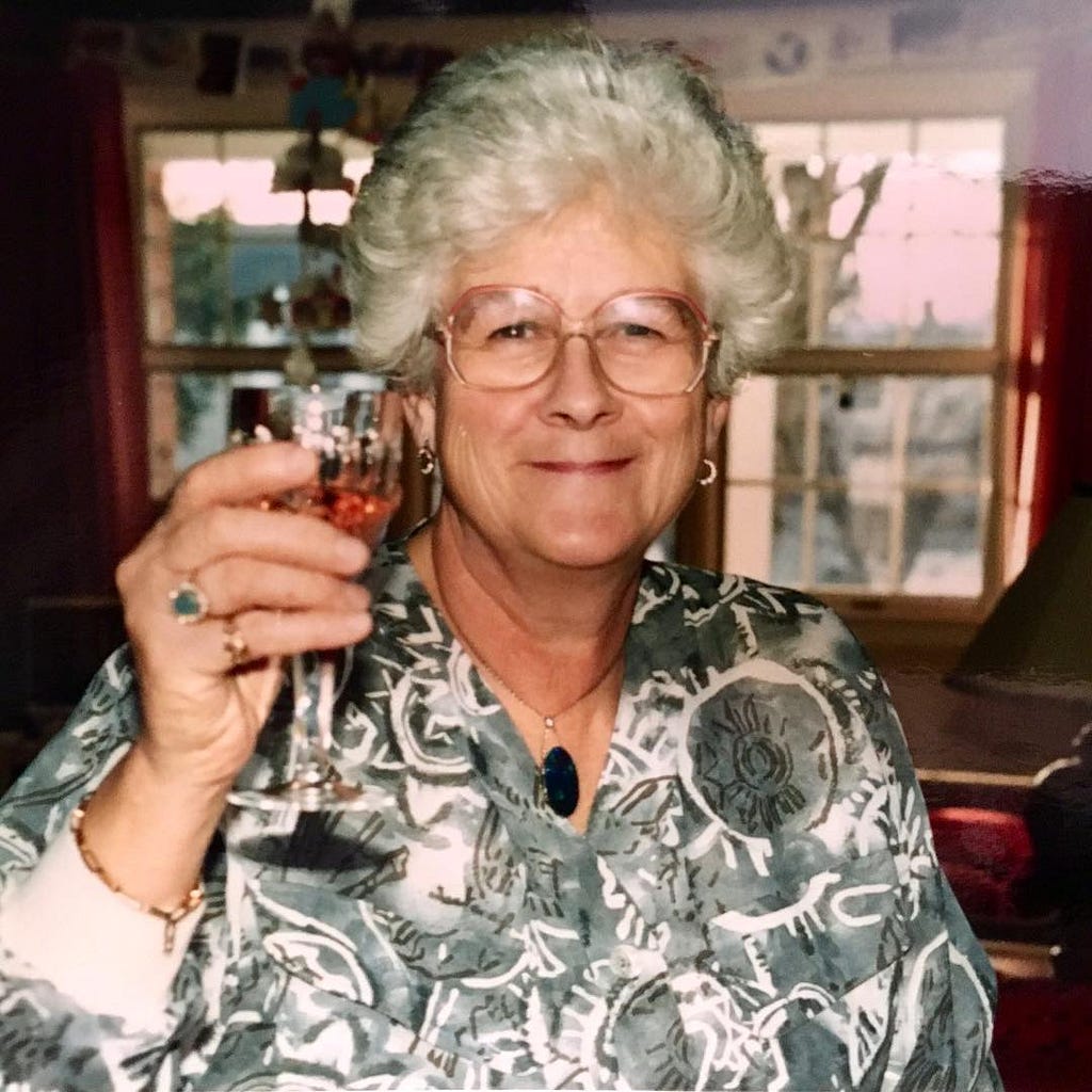 Granny smiling and holding up a drink