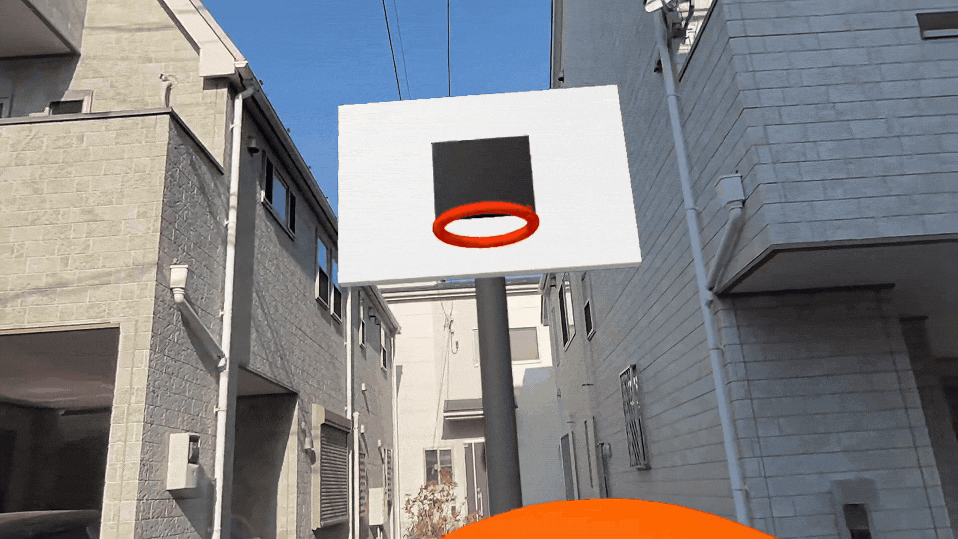 An animated gif of a player throwing the ball into the hoop in mixed reality, in the actual street