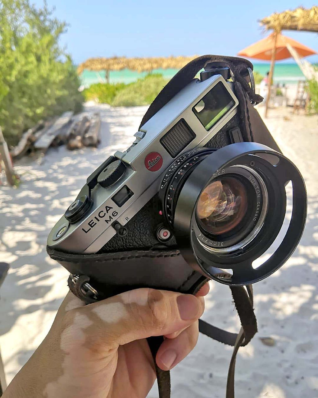 A Leica M6 camera with a halfcase leather case, in front of the beach in Yucatan, Mexico.