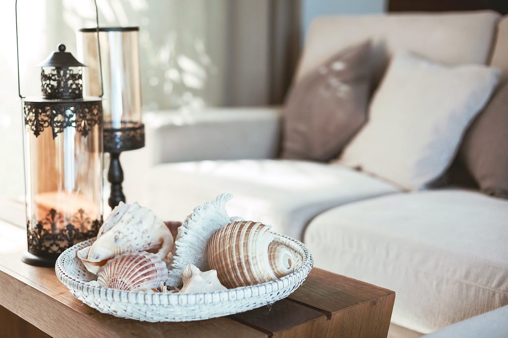 Beach-themed coffee table, with seashells and a lantern on a wooden table
