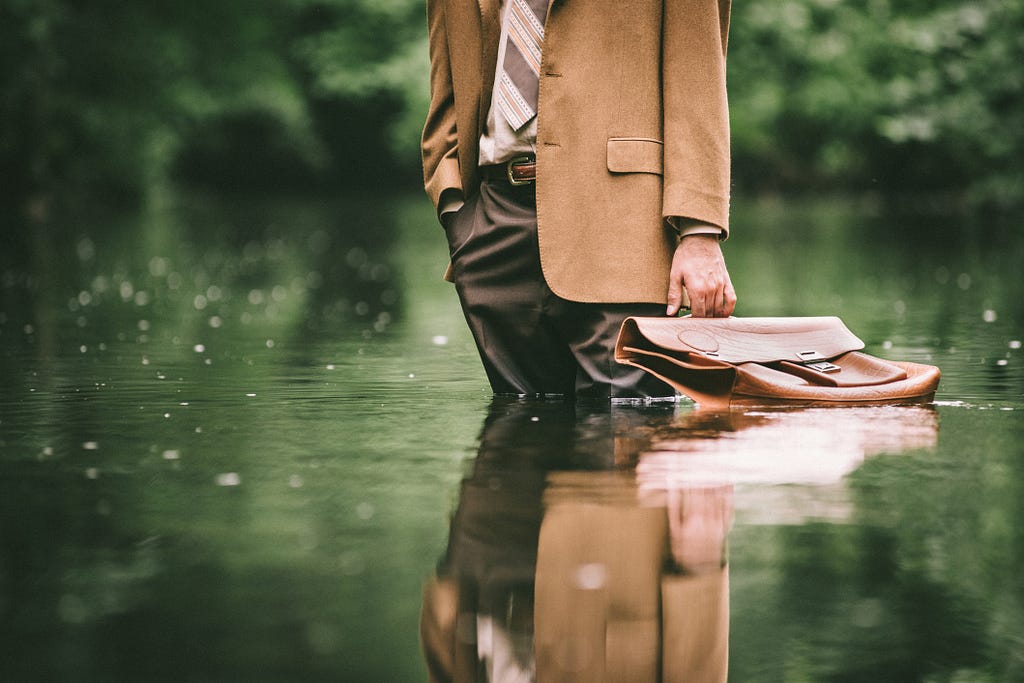 A photo of a businessman standing in water.