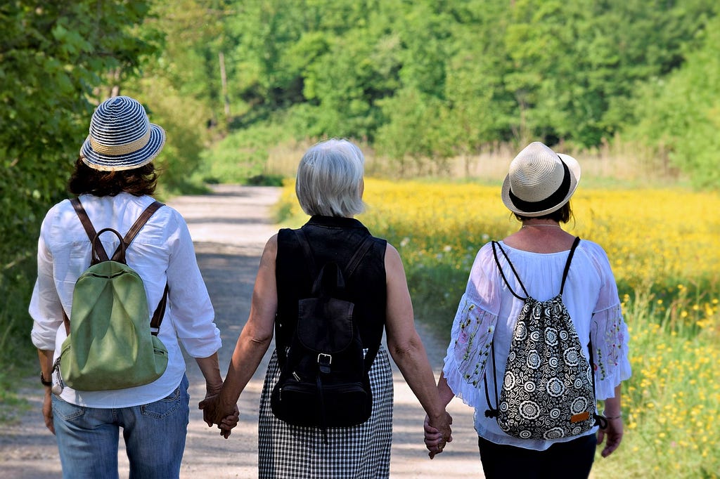 Three women together holding each other hands