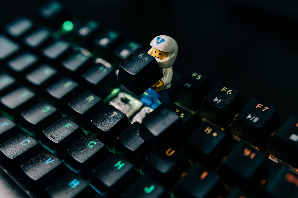 Lego character holding a keycap on top of a keyboard