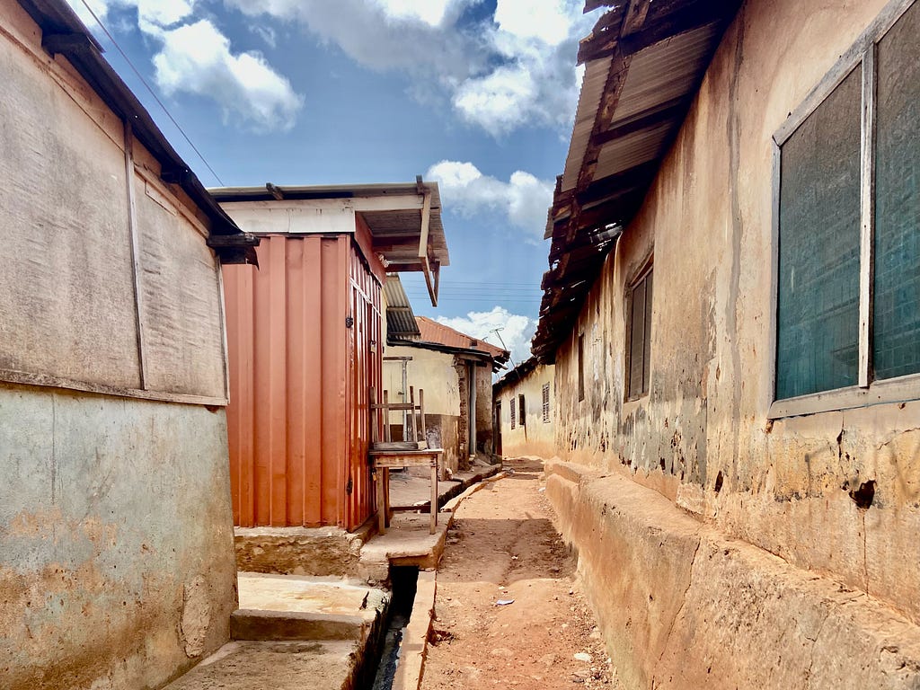 Photo of a narrow street in an informal settlement in Ghana