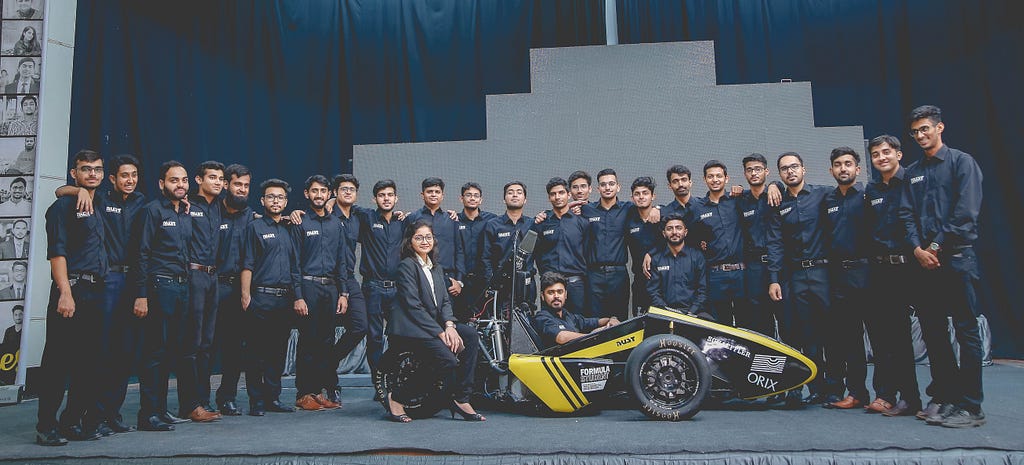 Team standing behind and around a prototype formula style car