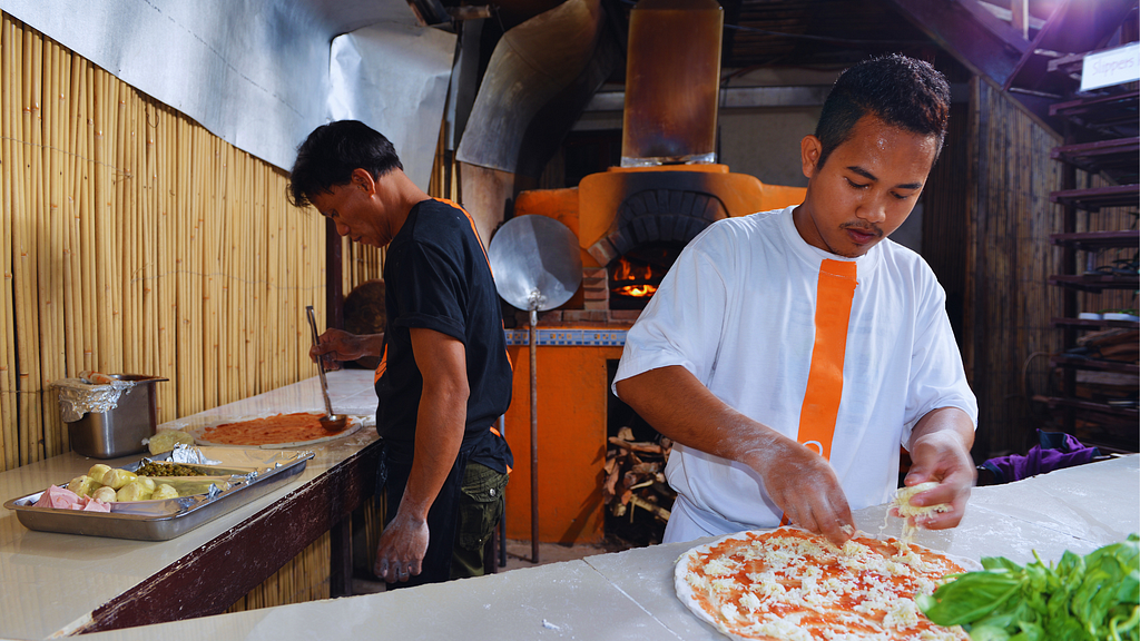 Two Filipino men working in a Filipino pizzeria.