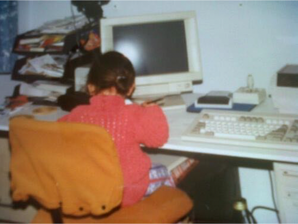 Young girl studiously at work in front of a vintage PC