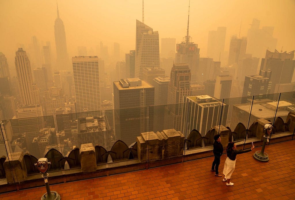 View of New York skyscrapers from the vantage point of a viewing platform with an orange sky from the pollution particiles from Canadian wildfires.