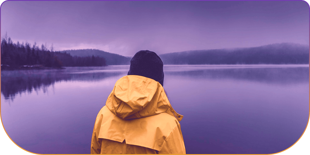 Man in yellow raincoat looking out to the open sea