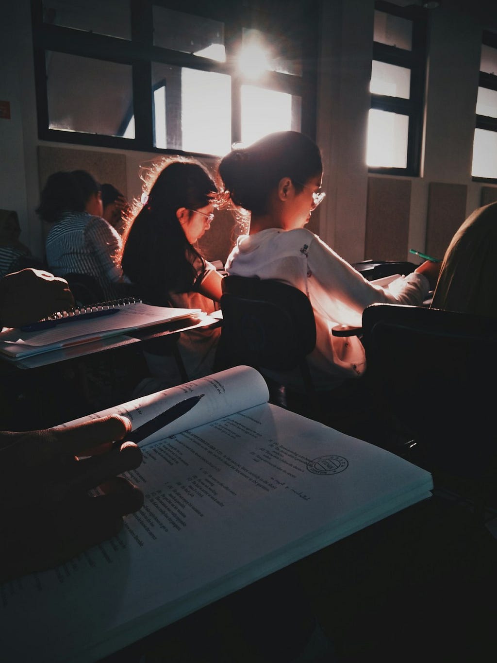 Students sitting at desks writing in books
