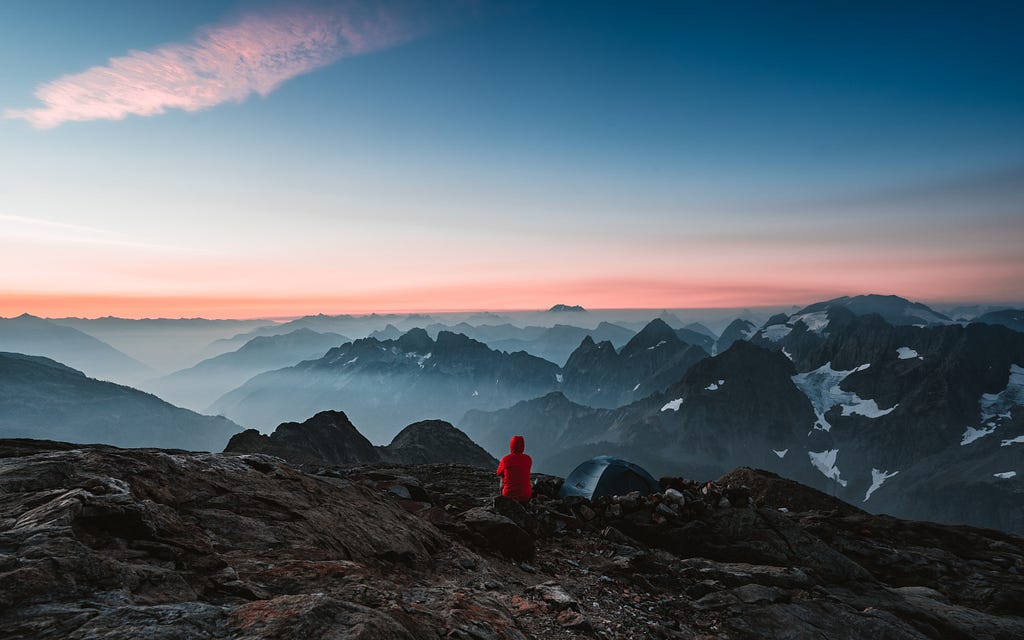 Sunrise above mountains in North cascade national park, Washington, United States. A beautiful moment where there are less tourist and a moment worth remembering as the background is filled with golden and pink hues with fog emerging from the mountains.