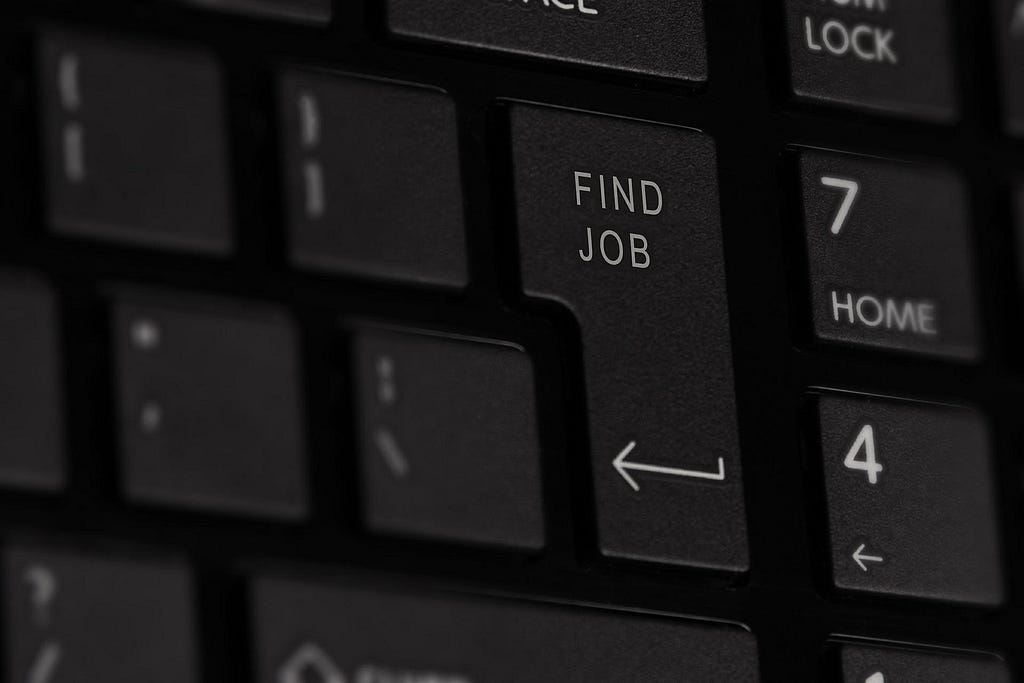 Close up keyboard image that says “find job” on the return key.