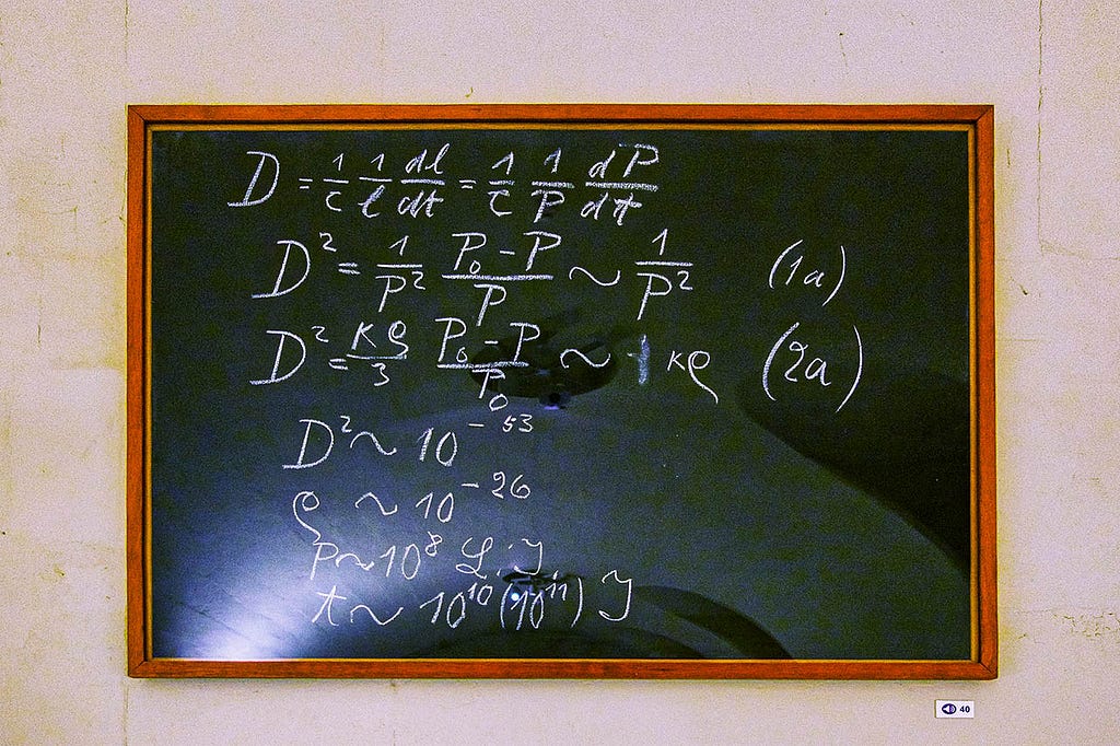 a chalkboard with a math equation written by albert einstein