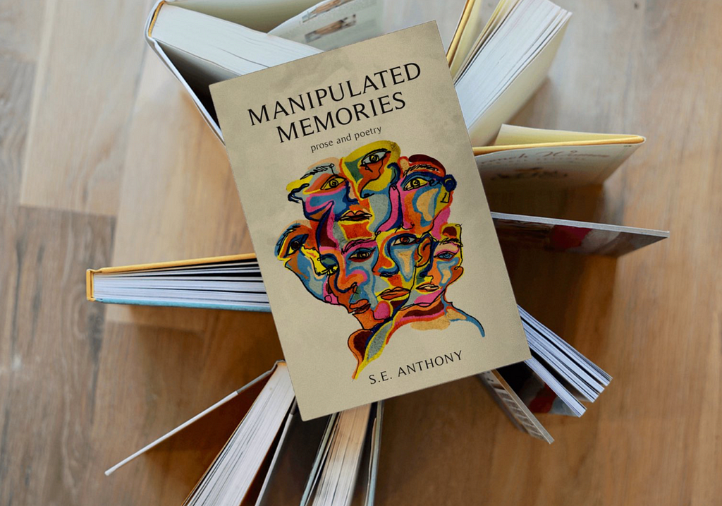 Copies of Manipulated Memories, by S.E. Anthony, are arranged on a wooden floor.