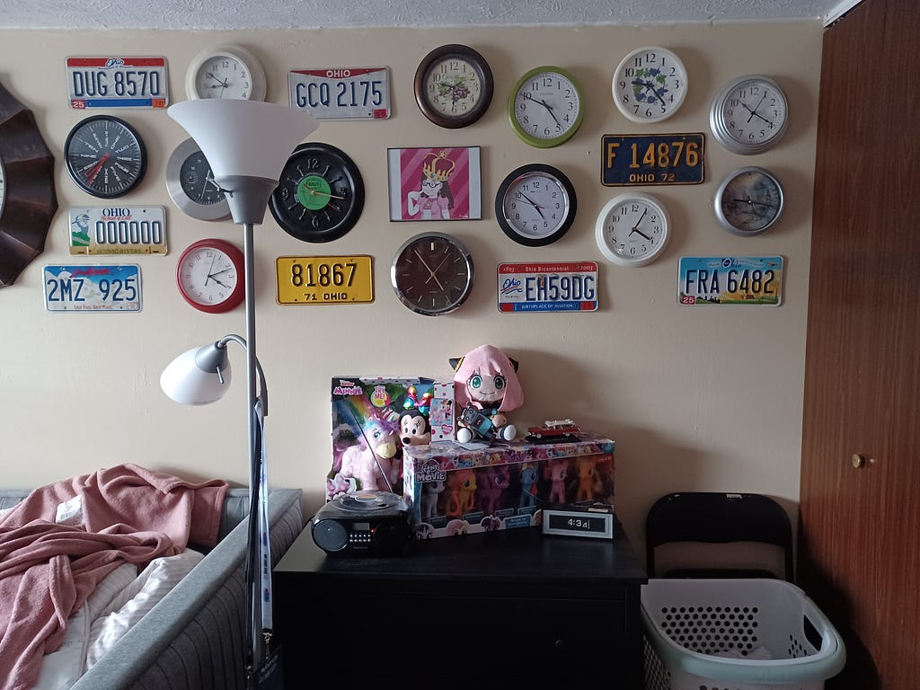about a dozen clocks (and several license plates) mounted on the wall above my dresser