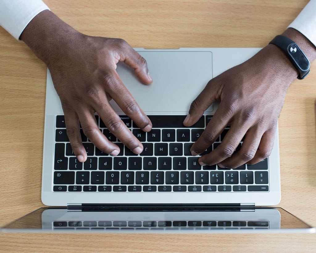 Man typing on a laptop.