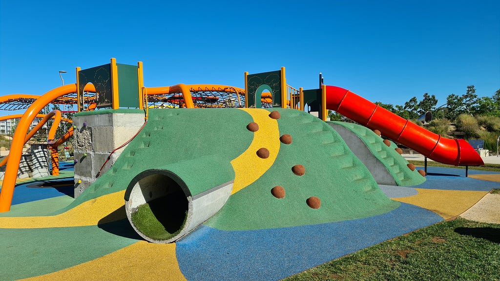 A children’s playground with slide, tunnel and climbing wall