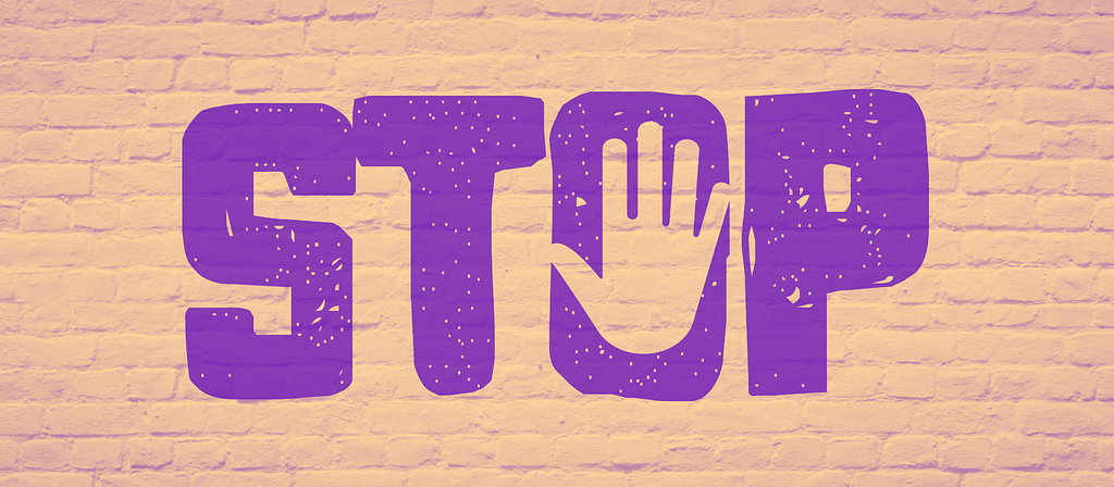 Image of the word “stop” painted on a brick wall with a human hand gesturing “stop” within the “O.”