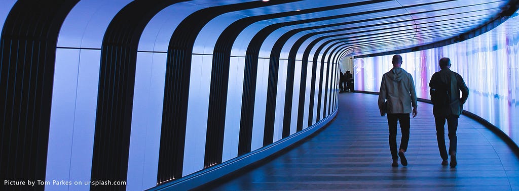 Two men walking down a corridor